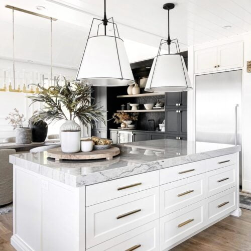 White kitchen island with marble countertop.