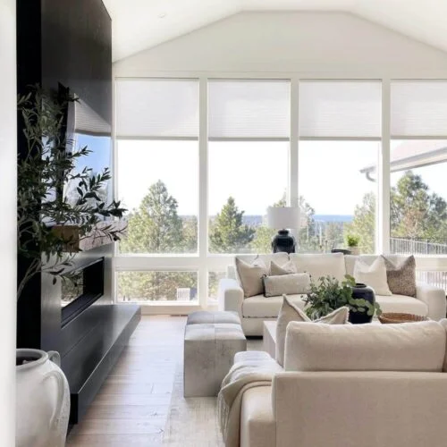 Modern living room with fireplace and view.