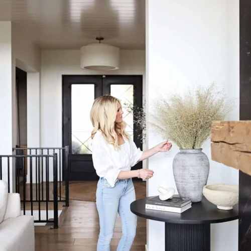 Woman in white shirt and jeans in a home.