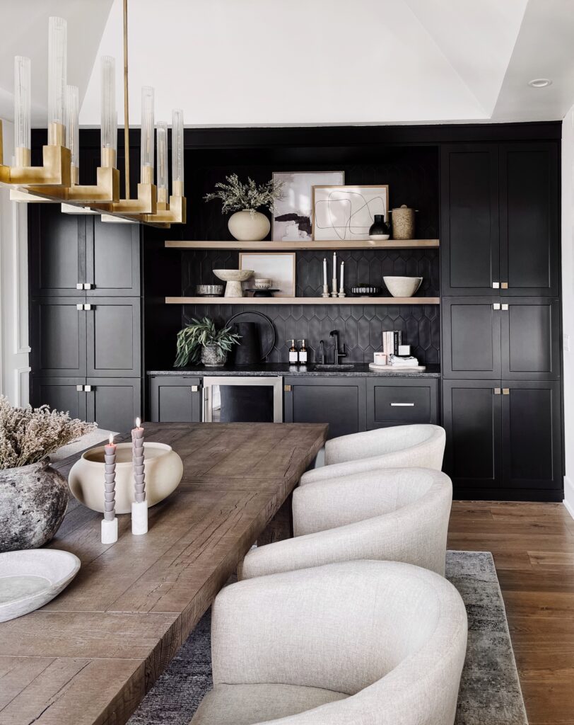 Modern dining room with black cabinets and wood table.