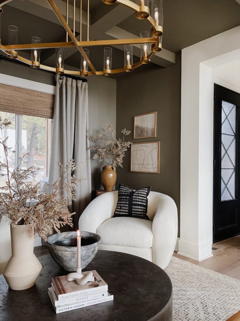 Living room with gold chandelier and white armchair.