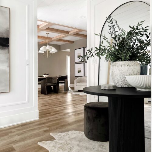 Modern entryway with black table and rug.