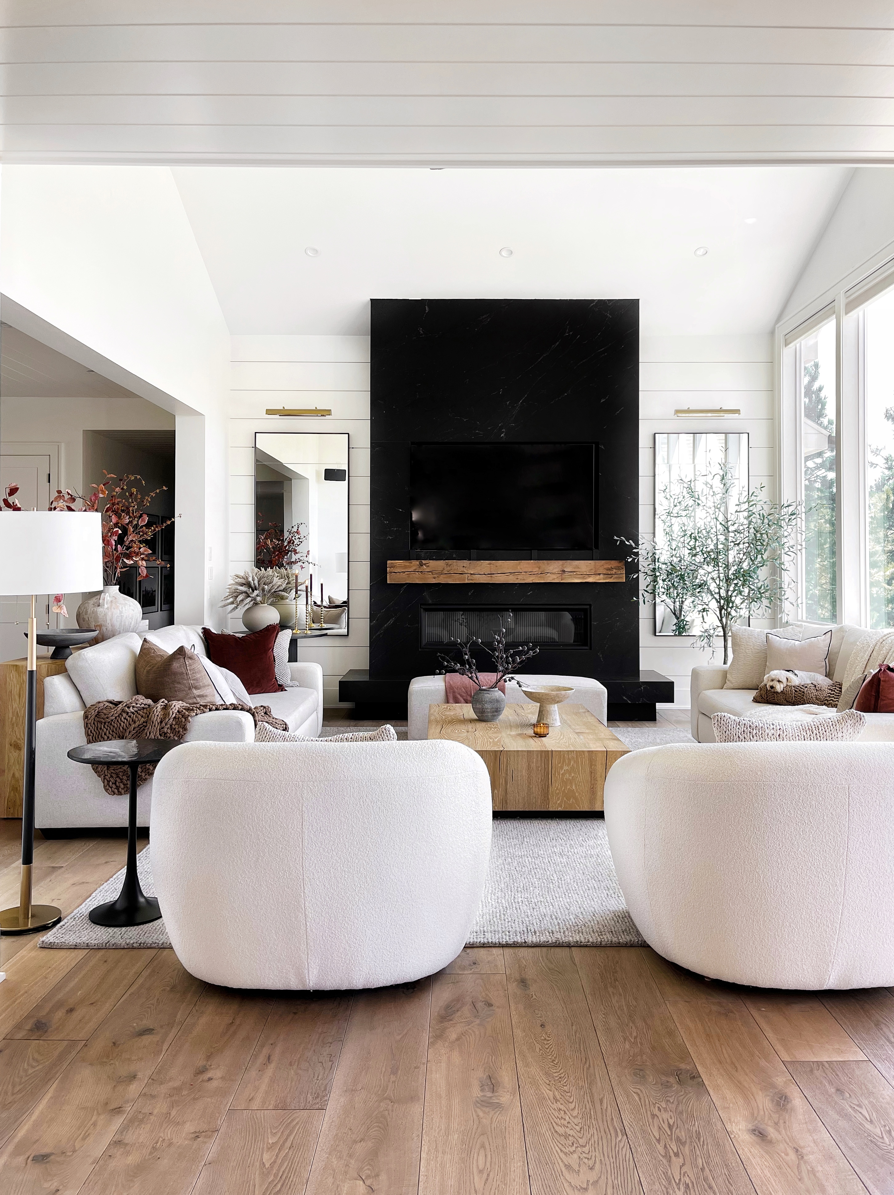 Modern living room with fireplace and white sofas.