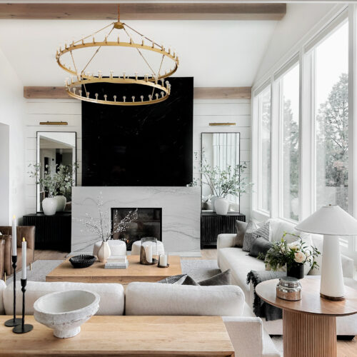 Modern living room with fireplace and chandelier.