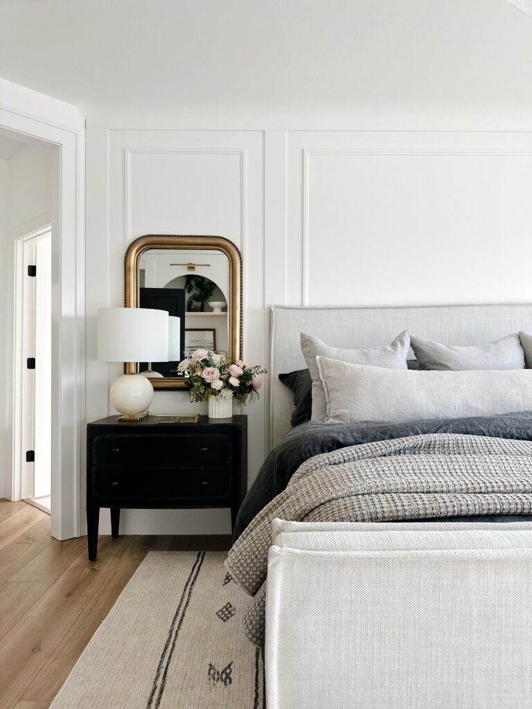 White bedroom with gray bed and rug.