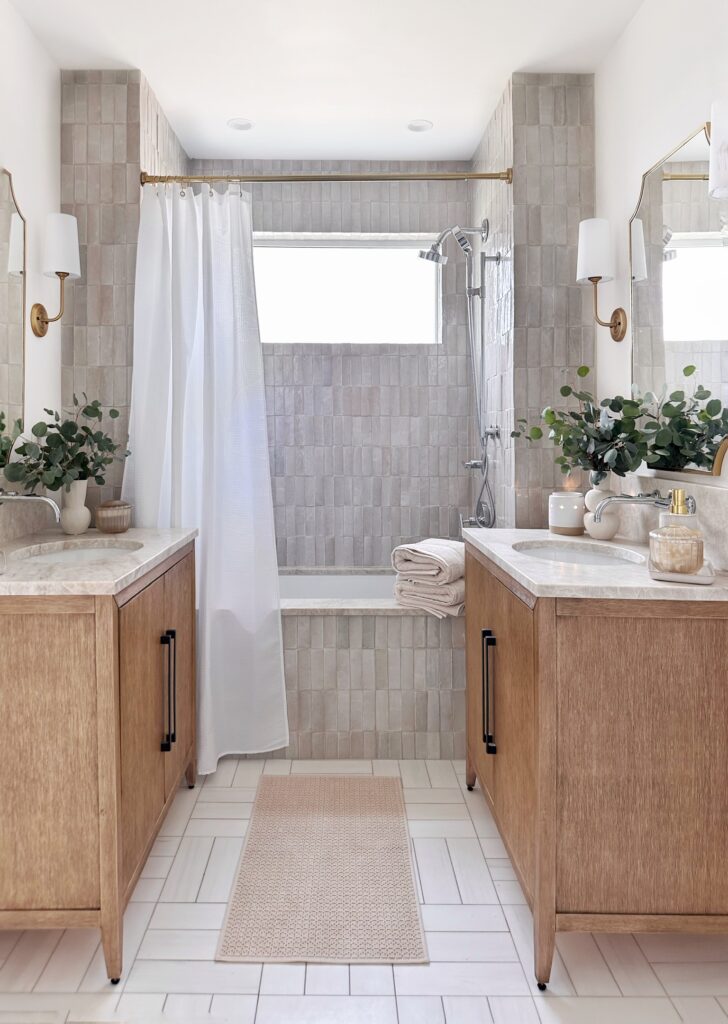 Modern bathroom with wood vanity and tub.