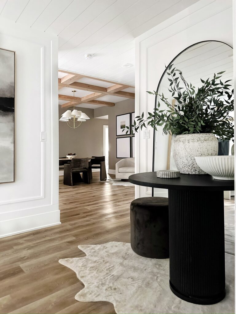 Modern entryway with black table and rug.