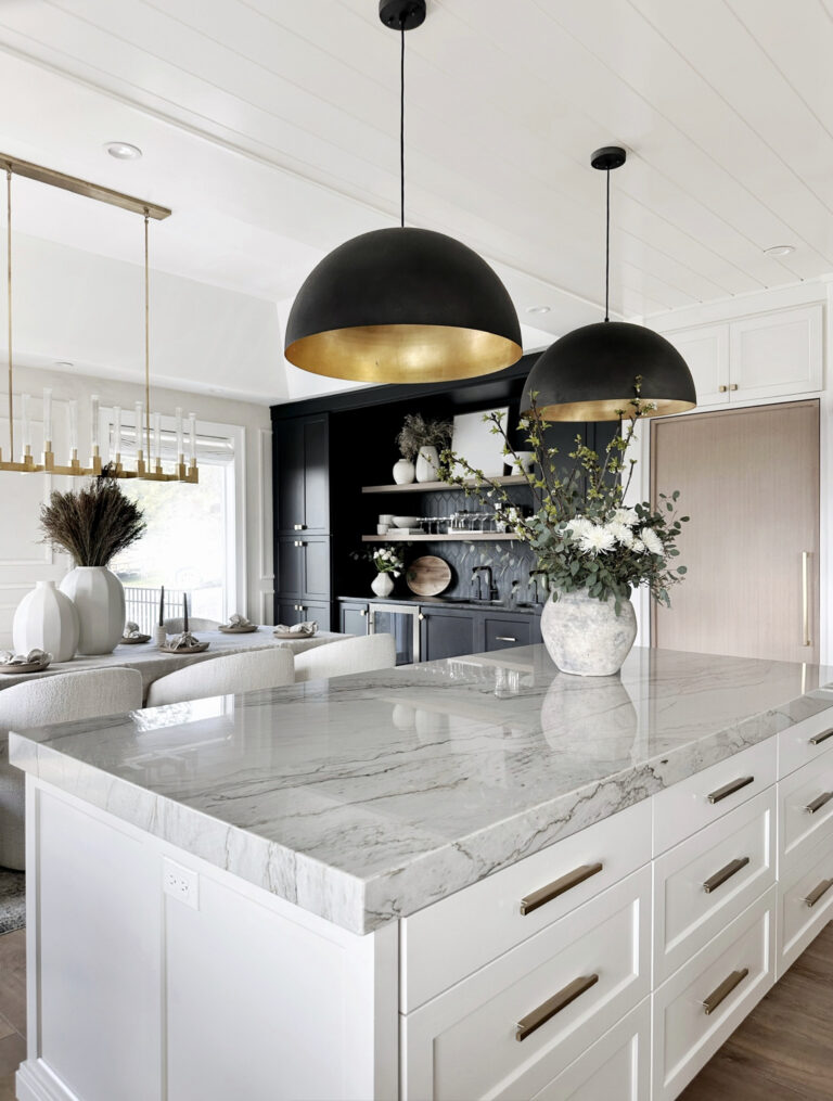 White kitchen island with marble countertop.