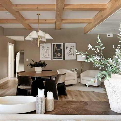 Modern living room with wood beams and art.