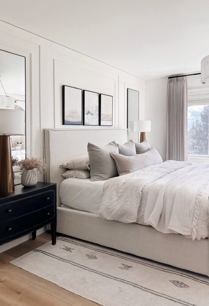 White bedroom with a large bed and rug.