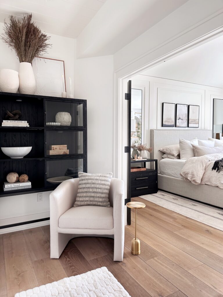 White chair with striped pillow in a living room.