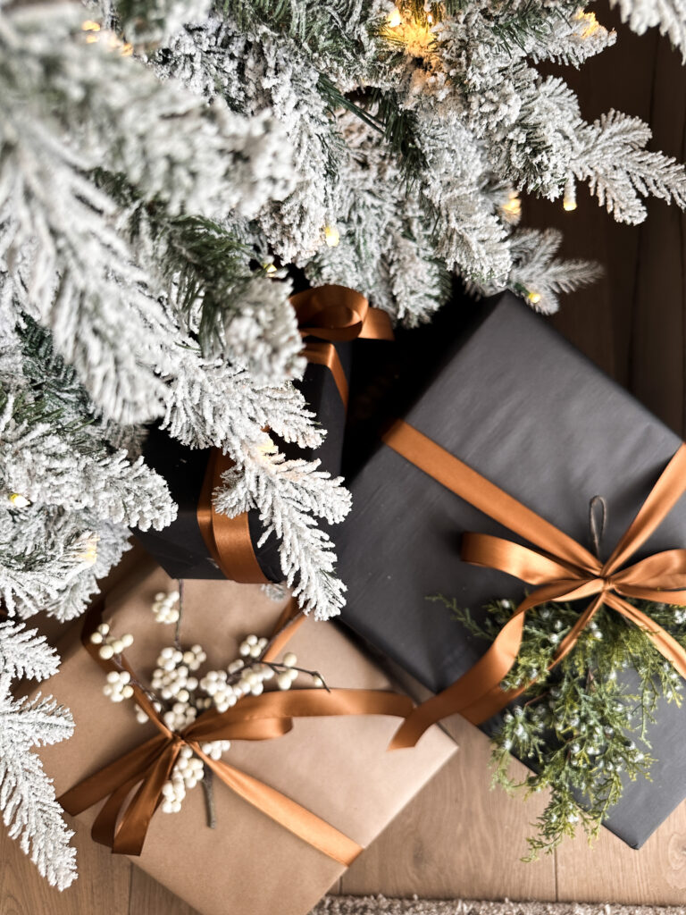 Gifts under a snowy Christmas tree.