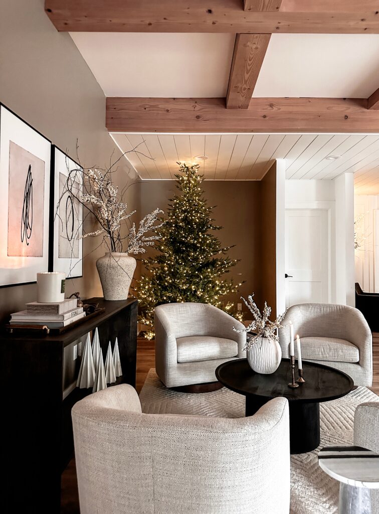 Living room with a Christmas tree and chairs.