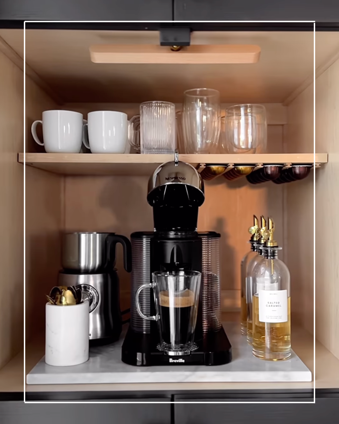 Espresso machine and coffee cups in a cabinet.