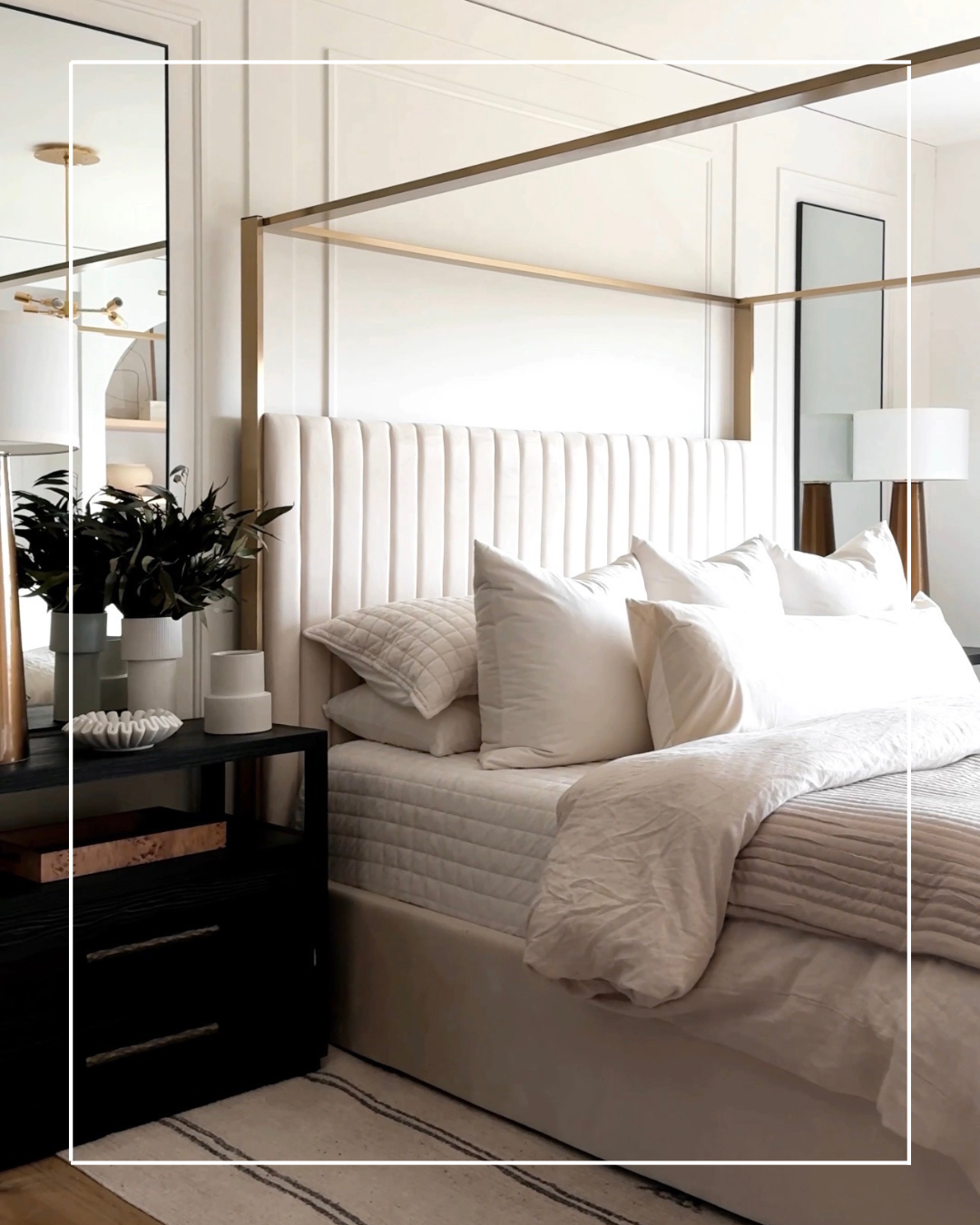 White canopy bed with gold frame in bedroom.