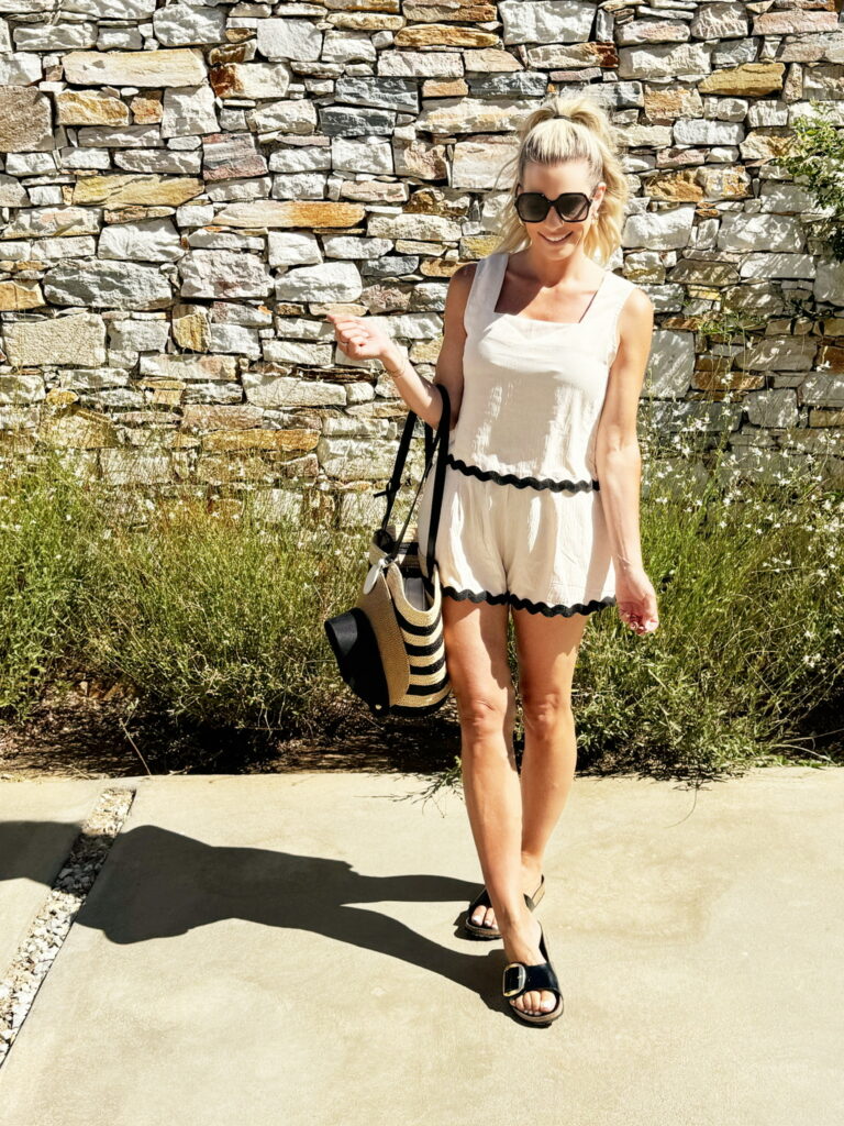 Woman in a white sundress with a straw bag.